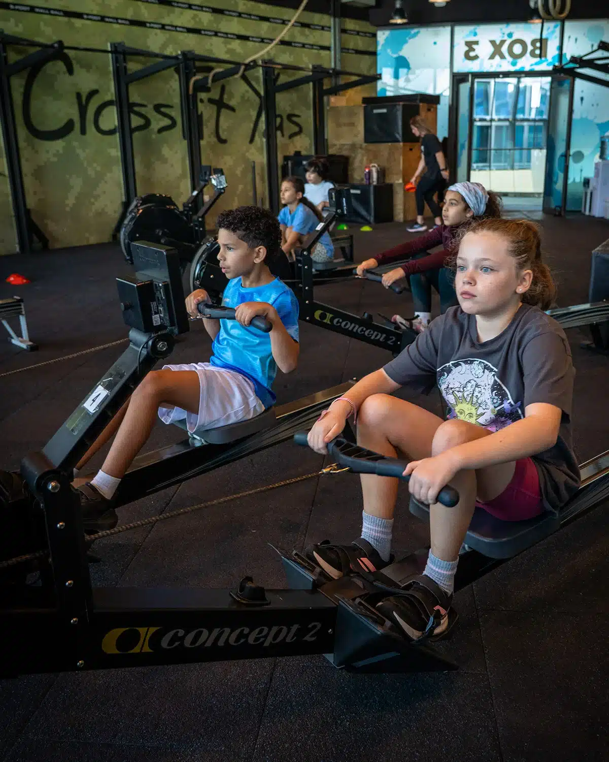 Children training together on rowing machines