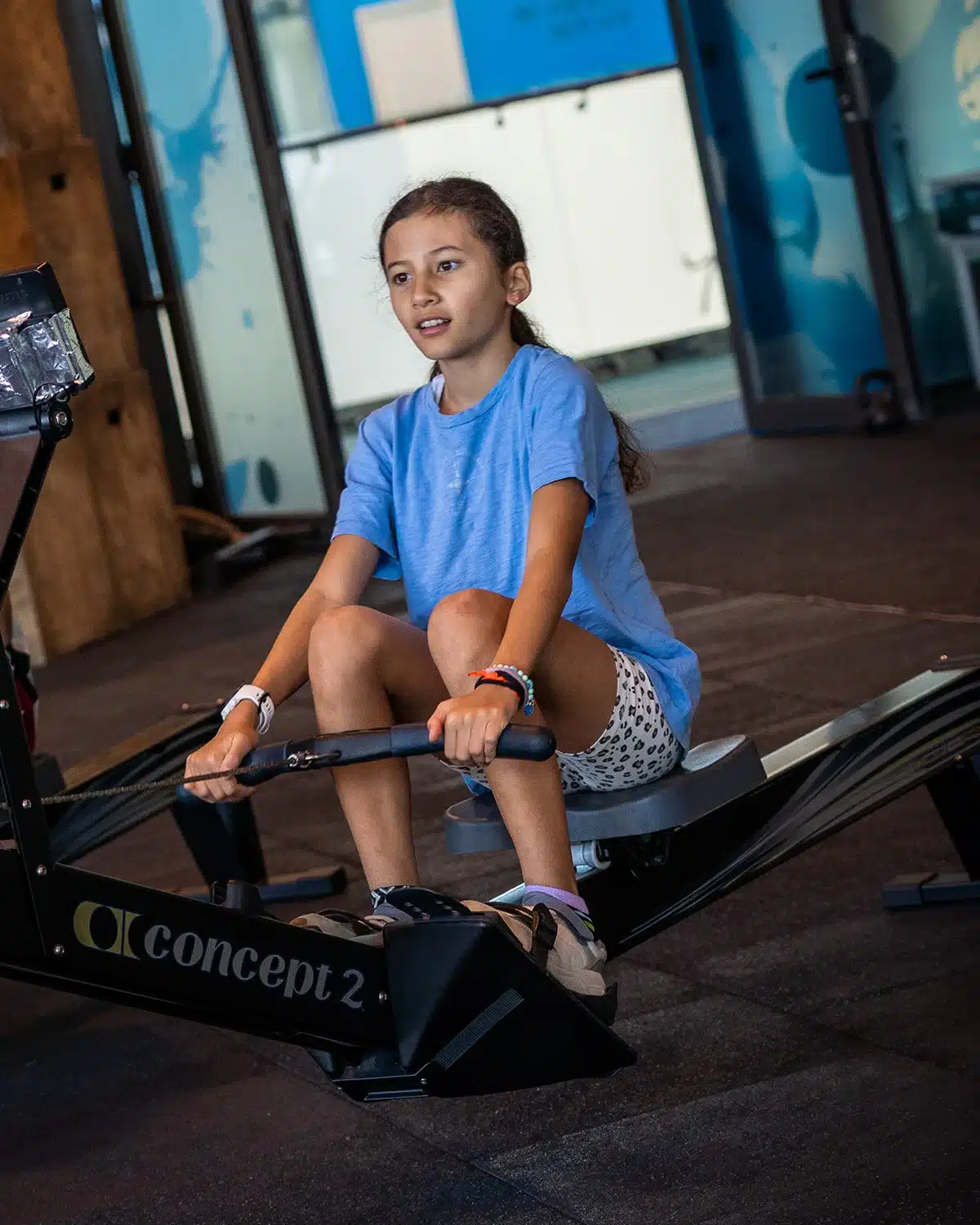 Young athlete training on a rowing machine